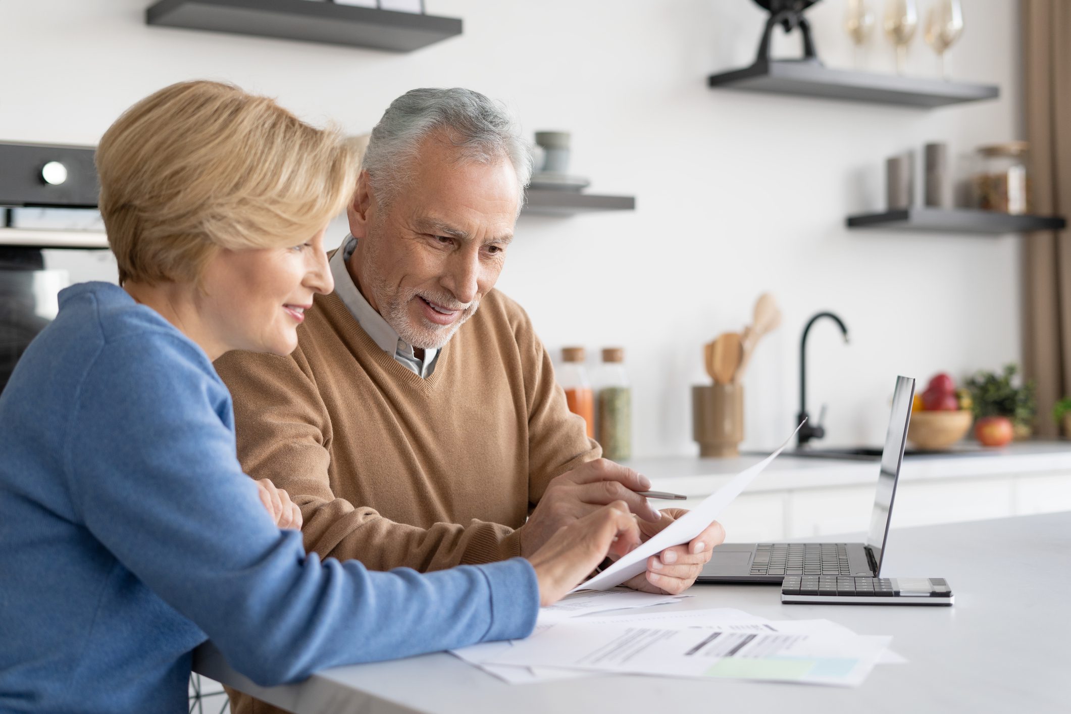 Older couple reviewing documents at home.