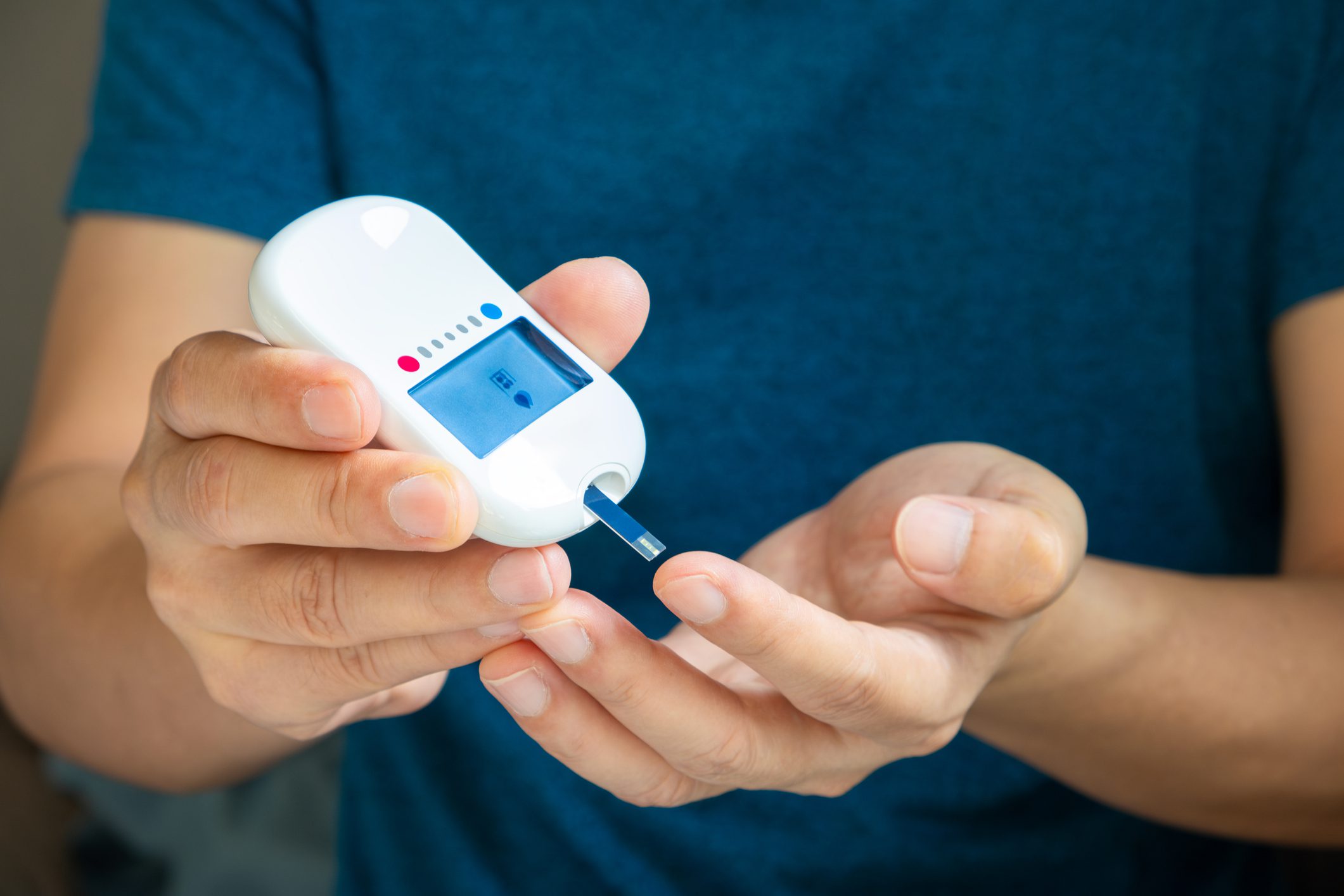 A woman draws blood on his finger and tests it for diabetes. Check high blood sugar levels with a digital blood sugar tester. Health care and medical concept